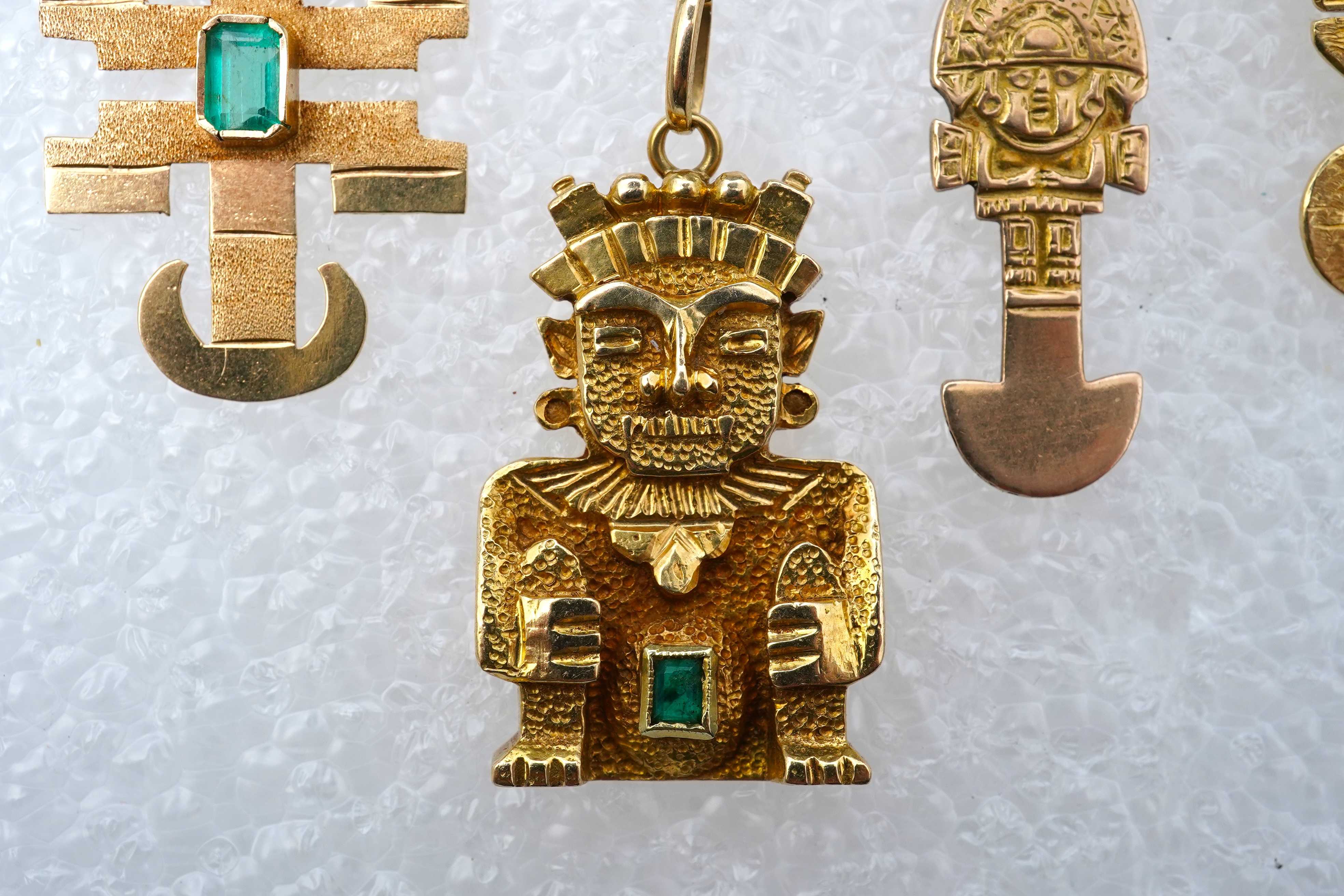 A collection of five gold pendants